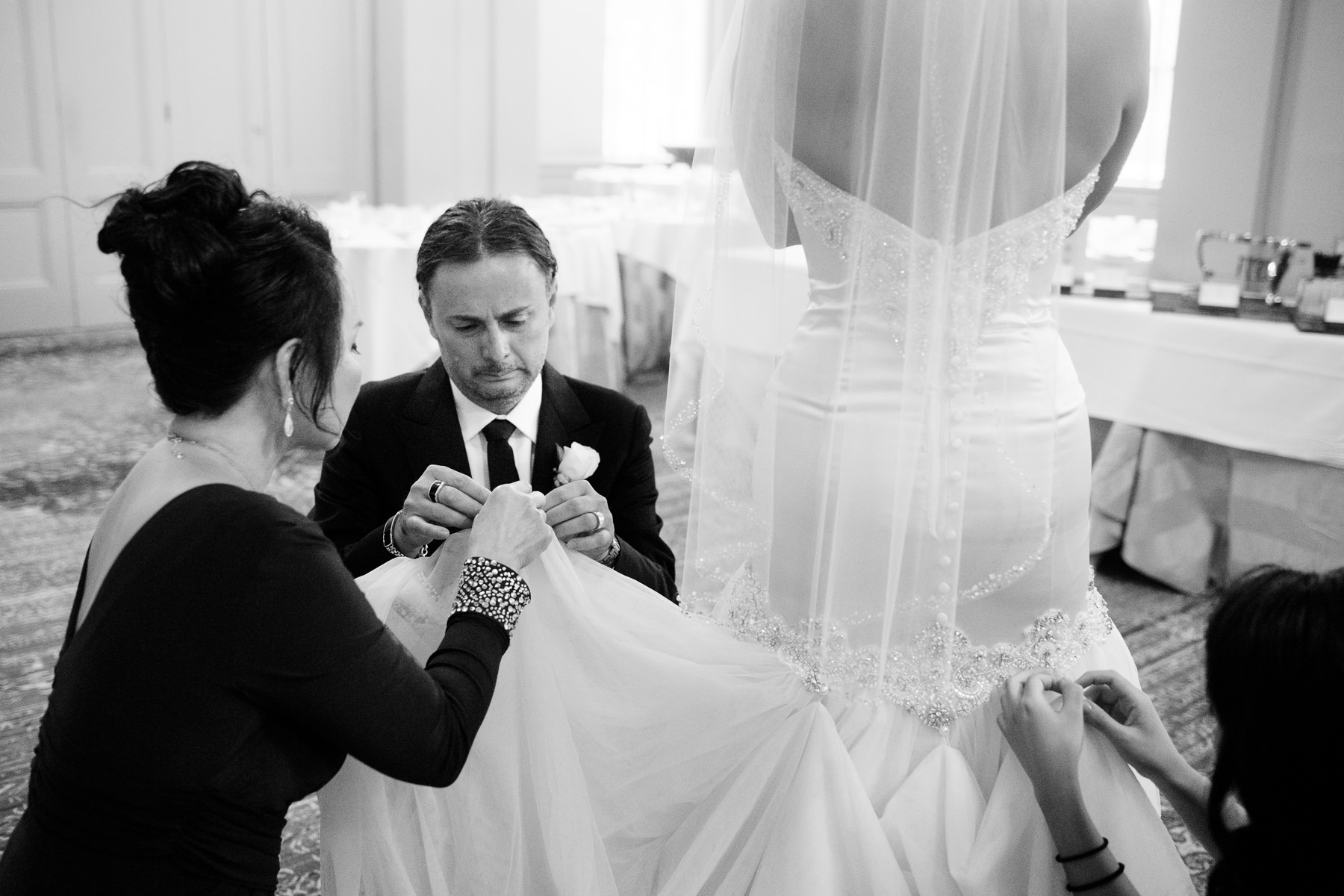 groom helping with wedding dress arctic club wedding