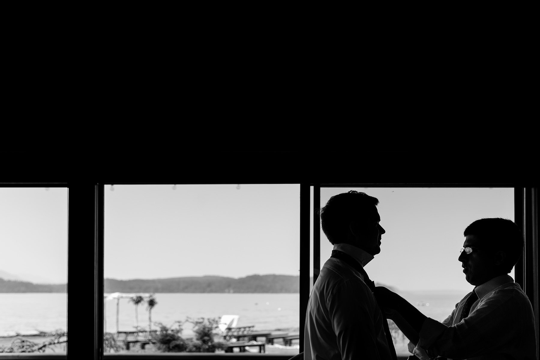 silhouette of groomsmen putting on ties