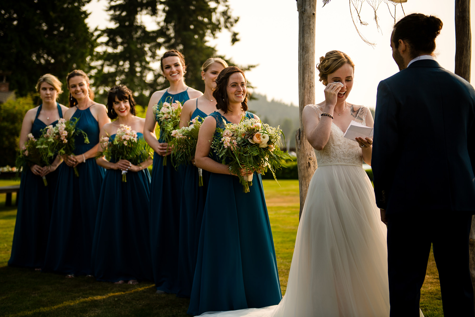 bride wiping tears away during wedding ceremony