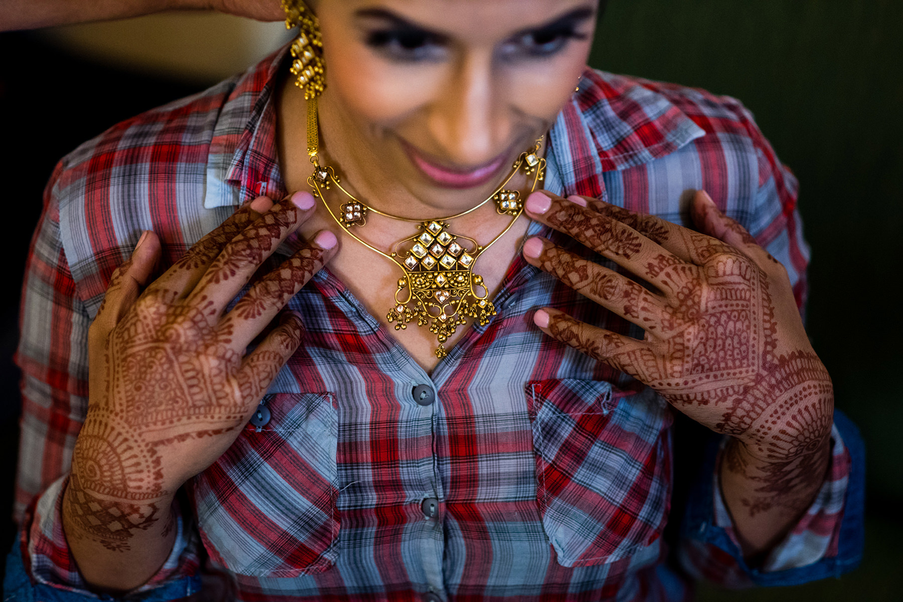 indian wedding bride putting on jewelry 