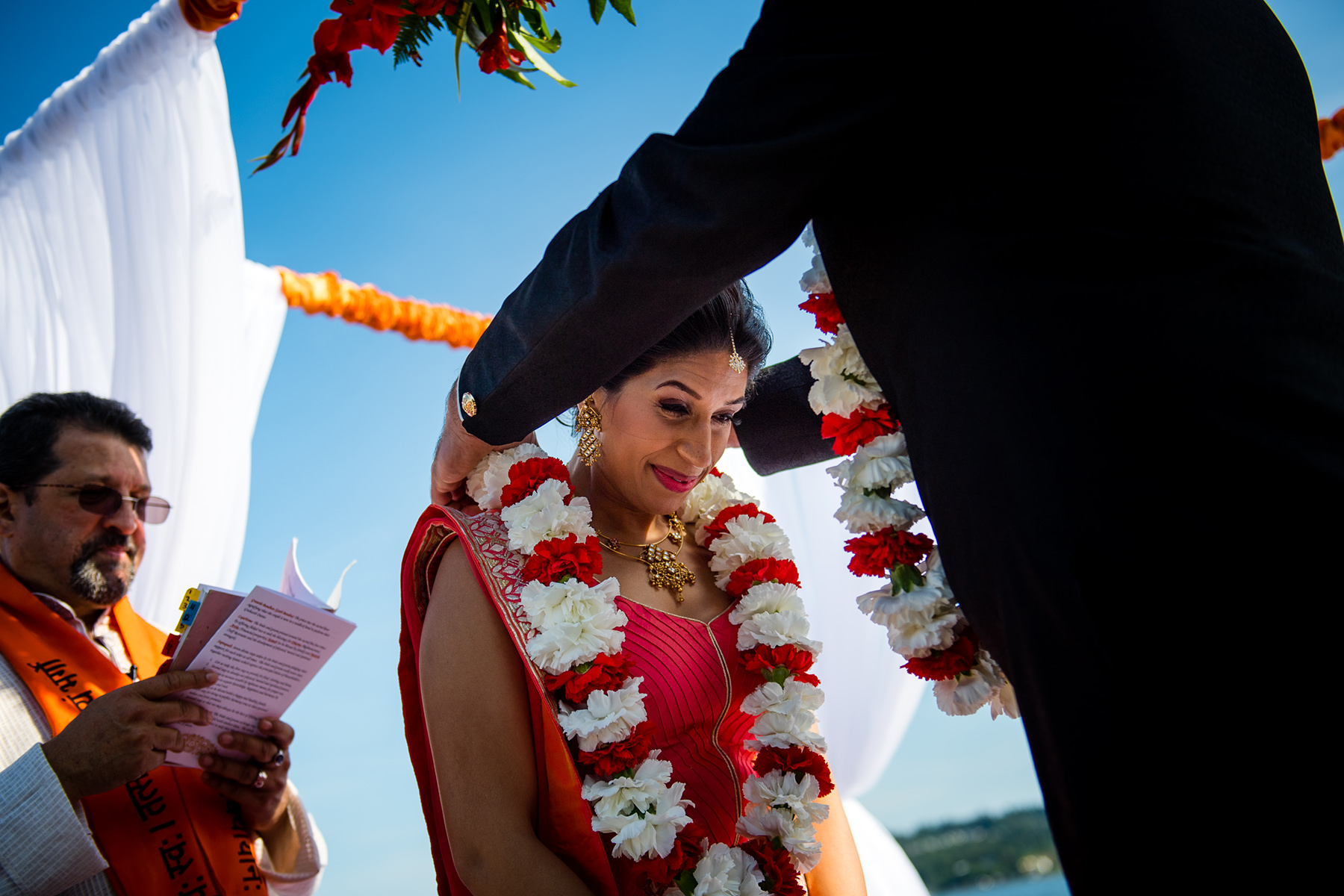 grooms gives bride neckless of flowers