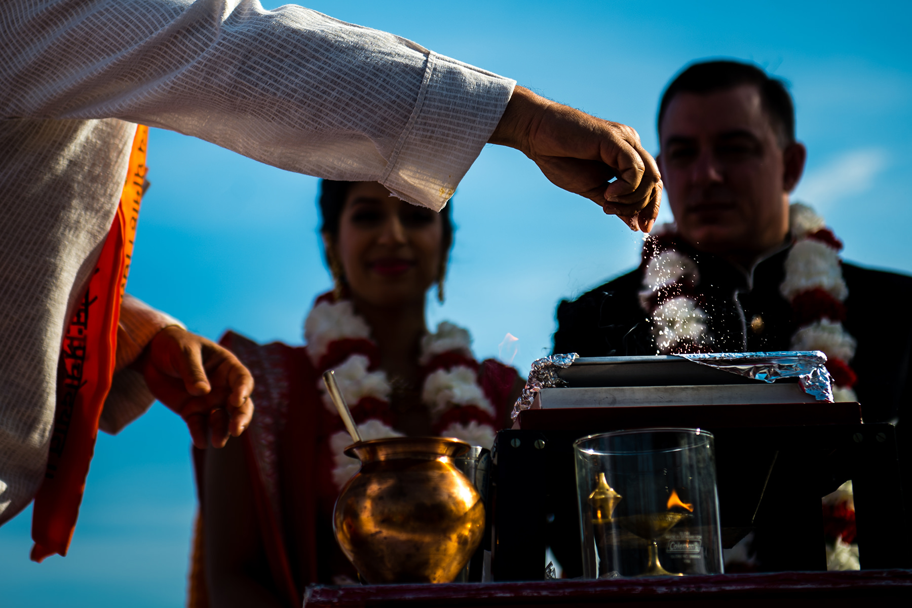 priest adds to fire during indian wedding ceremony