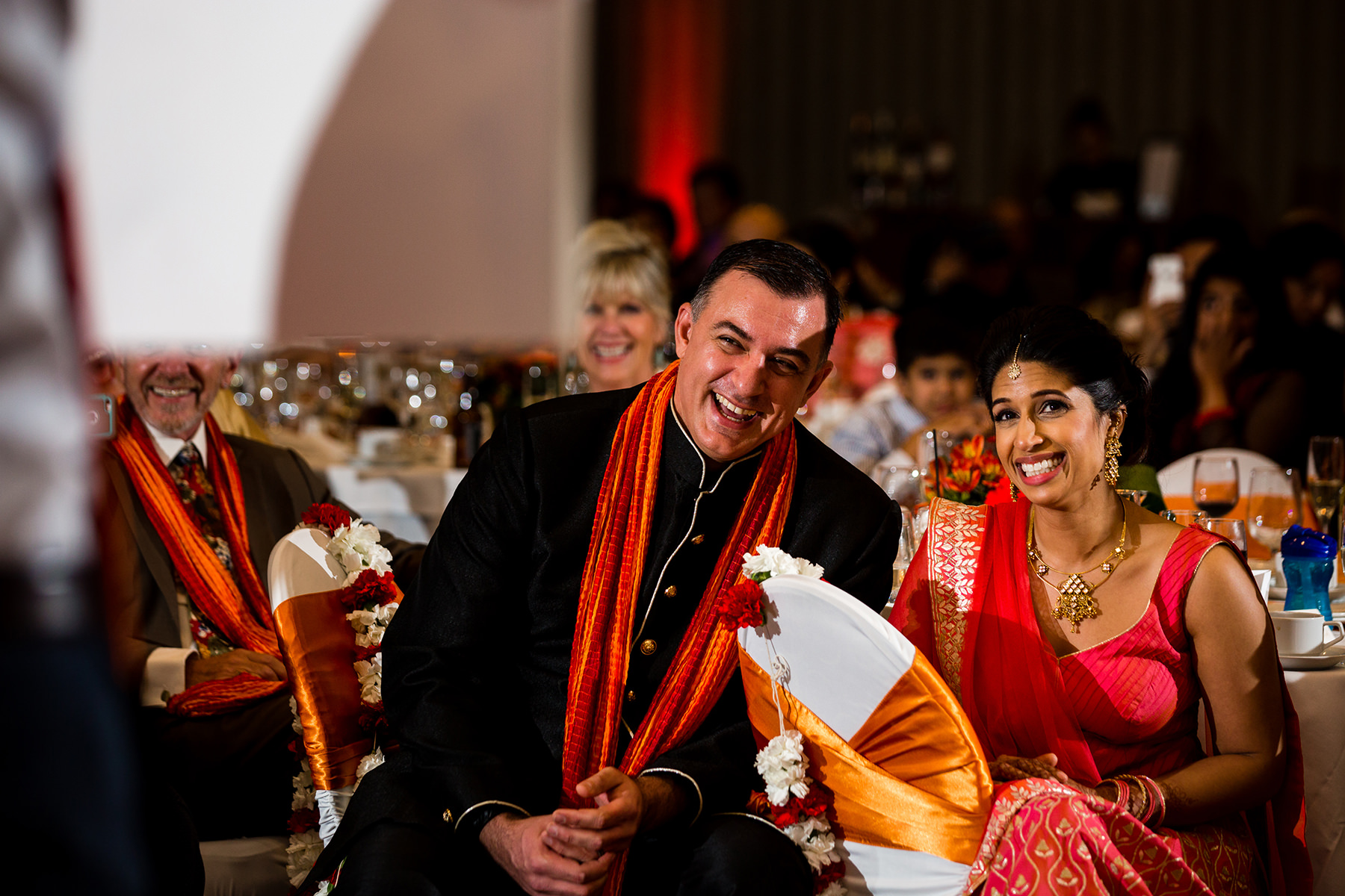 bride and groom laughing during wedding toasts